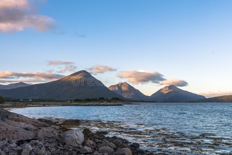 Rocky shore and sharp mountain peaks. stock photos Rocky shore and sharp mountain peaks. stock photos
