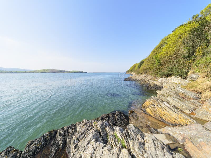 The rocky shoreline of the River Dwyryd on a bright spring day