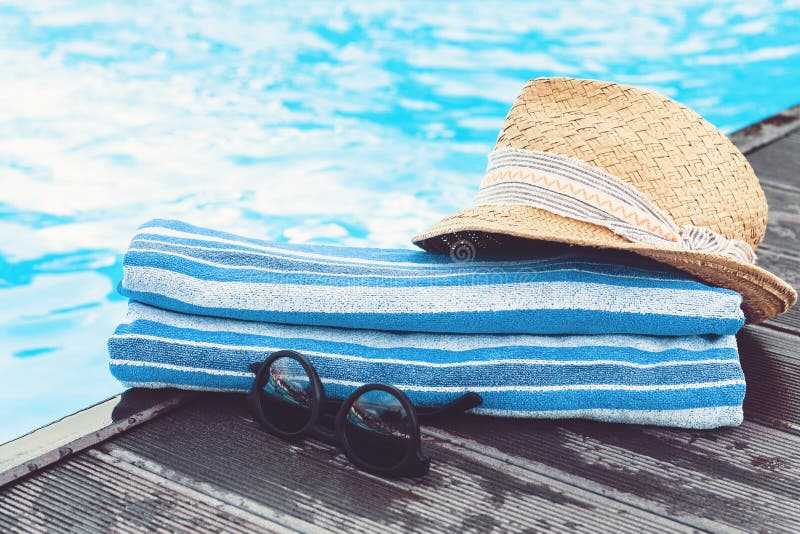 Rocznika lata słomy plaży łozinowy kapelusz, słońc szkła, błękitny ręcznikowy pobliski basen, tropikalny tło obrazy royalty free Rocznika lata słomy plaży łozinowy kapelusz, słońc szkła, błękitny ręcznikowy pobliski basen, tropikalny tło obrazy royalty free