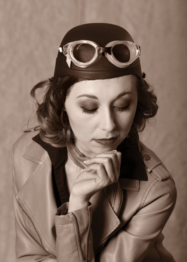 Rocznika stylowy portret jest ubranym gogle i leahter kurtkę lotnik kobieta