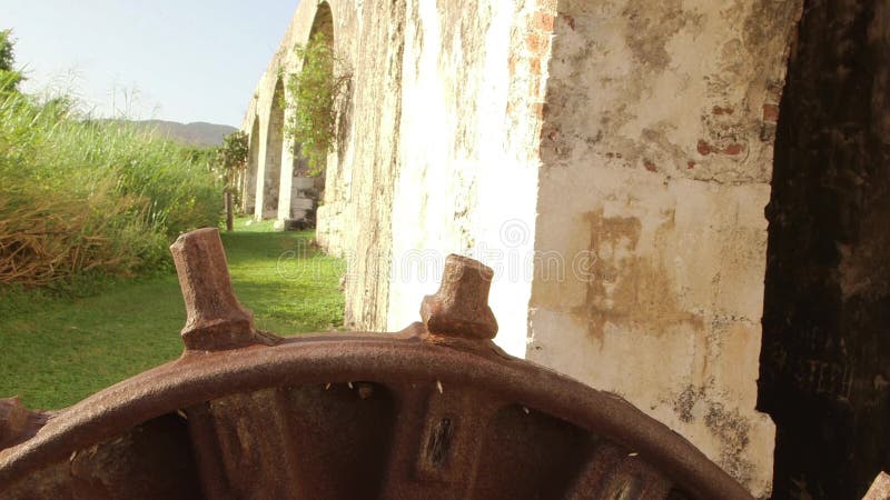 Roda de engrenagem antiga que senta-se ao lado do aqueduto do século XVIII Montego Bay, Jamaica