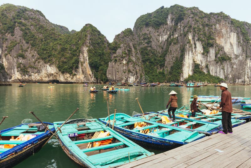 Roddmän och kvinnor som bär väntande turister för asiatisk konisk hatt på fartyg, stoppar över smaragdvatten arkivbilder Roddmän och kvinnor som bär väntande turister för asiatisk konisk hatt på fartyg, stoppar över smaragdvatten arkivbilder