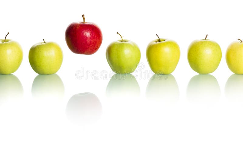 Rode appel die van rij van groene appelen duidelijk uitkomt. stock afbeelding Rode appel die van rij van groene appelen duidelijk uitkomt. stock afbeelding