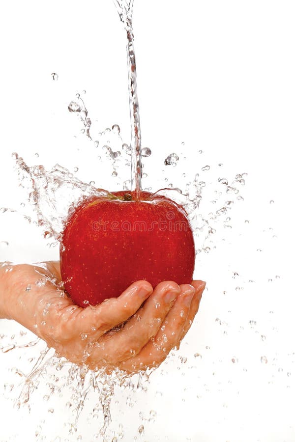 Red apple in hand under flowing water on a white background. Red apple in hand under flowing water on a white background