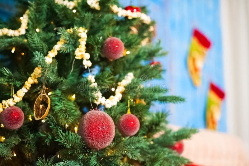Rode Kerstmisballen op een Kerstboom op een achtergrond van blauwe oude deuren in de verfraaide Nieuwjaar` s ruimte Slinger van p