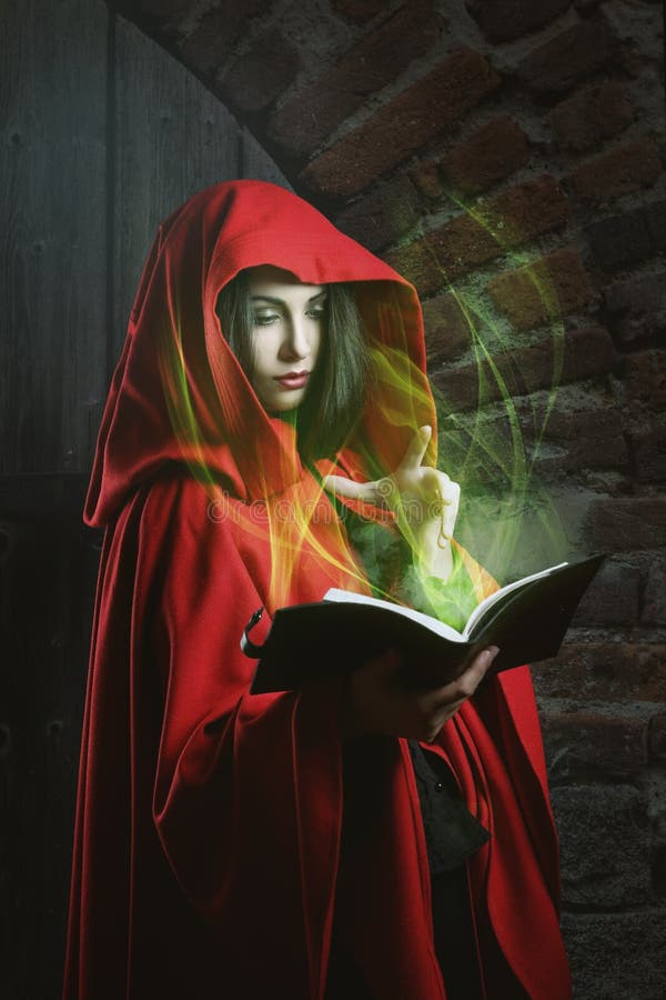 Red hooded woman reading a magical book . Dark fantasy portrait. Red hooded woman reading a magical book . Dark fantasy portrait