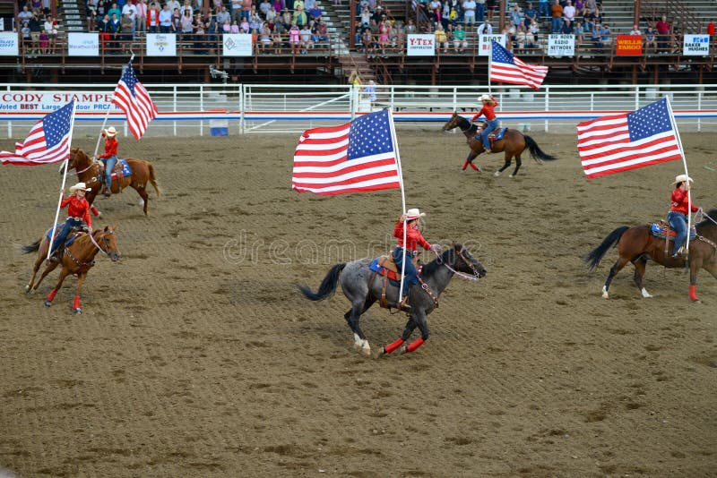 Cody, Wyoming, 07/12/2013
horseback riding with american flags  at rodeo in Cody. Cody, Wyoming, 07/12/2013
horseback riding with american flags  at rodeo in Cody