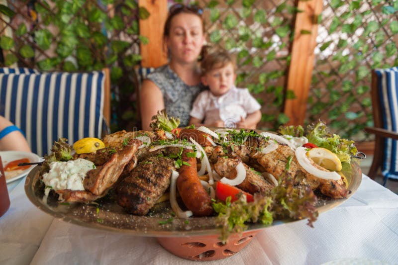 Rodi, Grecia 30 maggio 2018 Piatto di Meze con alimento locale tradizionale sulla tavola in ristorante locale davanti ad una fami fotografie stock Rodi, Grecia 30 maggio 2018 Piatto di Meze con alimento locale tradizionale sulla tavola in ristorante locale davanti ad una fami fotografie stock