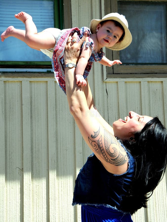 AUGUST 1, 2015. CASPER, Wyoming. CIRCA: Tribal native american mother and daughter celebrating the first year birthday of the daughter with love and affection. AUGUST 1, 2015. CASPER, Wyoming. CIRCA: Tribal native american mother and daughter celebrating the first year birthday of the daughter with love and affection.