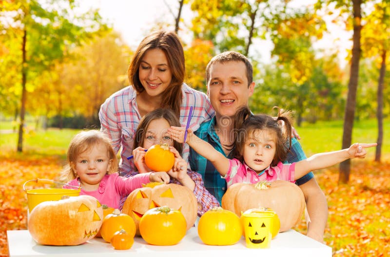 Rodzina rzeźbi banie dla Halloween w ogródzie zdjęcia stock Rodzina rzeźbi banie dla Halloween w ogródzie zdjęcia stock