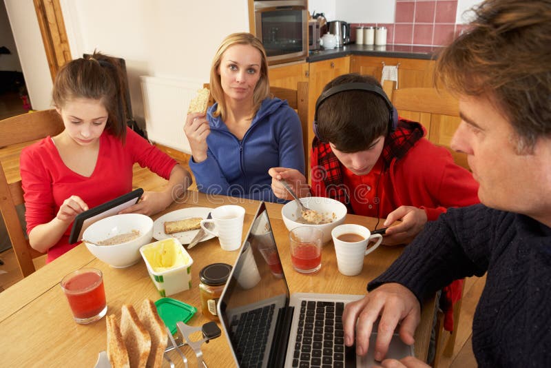 Rodzina Używać Gadżety Podczas gdy Jedzący Śniadanie