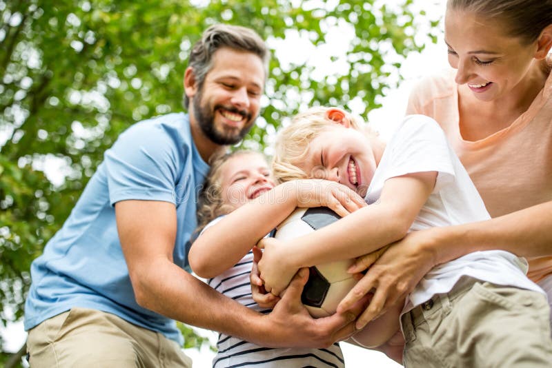 Family has fun with football and fight over the ball. Family has fun with football and fight over the ball