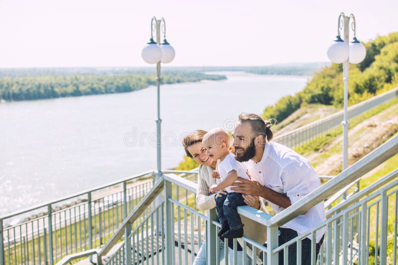Rodzinny mama tata, dziecko szczęśliwi z uśmiechami w parku w i wpólnie zdjęcia stock Rodzinny mama tata, dziecko szczęśliwi z uśmiechami w parku w i wpólnie zdjęcia stock