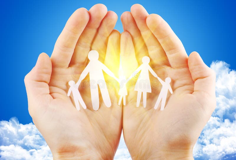 Paper family in hand sun and blue sky with copyspace showing freedom or solar power concept. Paper family in hand sun and blue sky with copyspace showing freedom or solar power concept