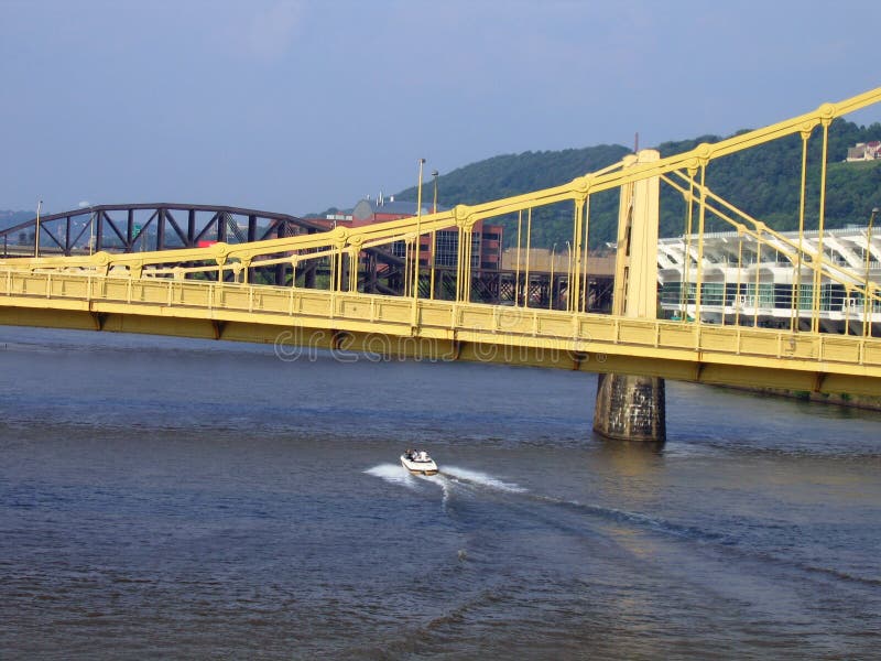 A Motor Boat Traveling Under A Bridge In Pittsburgh. A Motor Boat Traveling Under A Bridge In Pittsburgh