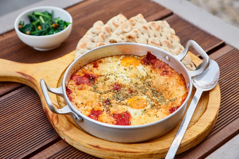 Roereieren met tomaten, kaas en kruiden in een aluminiumpan met handvatten met eigengemaakte dunne lavash en sappige greens stock foto's Roereieren met tomaten, kaas en kruiden in een aluminiumpan met handvatten met eigengemaakte dunne lavash en sappige greens stock foto's