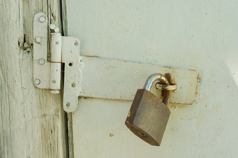 Roestig gesloten slot op oude houten witte gebarsten geschilderde deur stock fotografie Roestig gesloten slot op oude houten witte gebarsten geschilderde deur stock fotografie