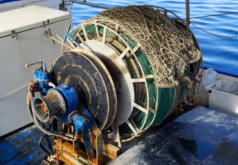 Roestige kaapstanderkruk van treiler vissersboot met visnet op het stock foto Roestige kaapstanderkruk van treiler vissersboot met visnet op het stock foto