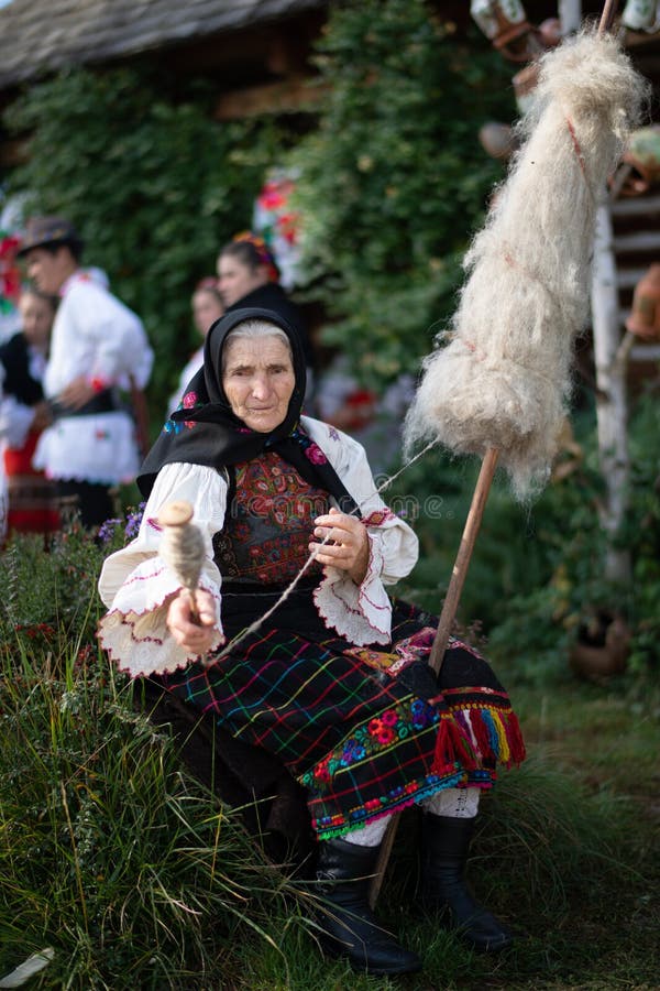 Rogoz, Romania, October 12th, 2019, Portraiture of woman wearing traditional in Maramures with her spindle for distaff