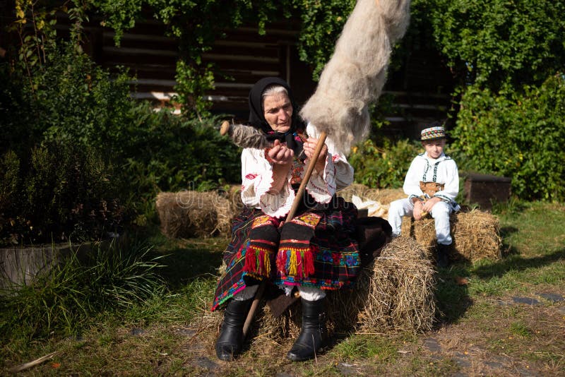 Rogoz, Romania, October 12th, 2019, Portraiture of woman wearing traditional in Maramures with her spindle for distaff