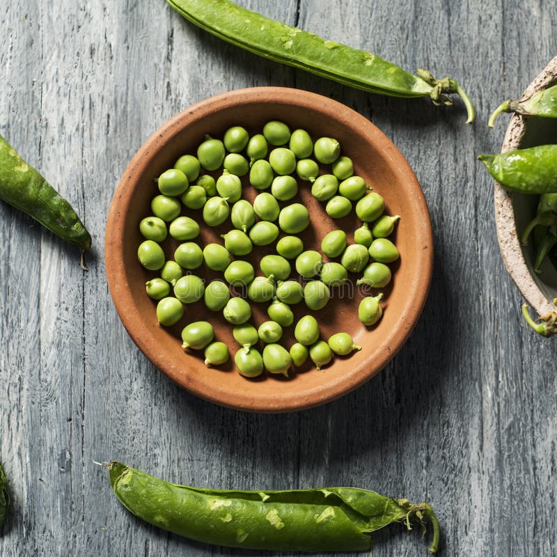 Rohe frische grüne Erbsen auf einer Tabelle stockfotografie Rohe frische grüne Erbsen auf einer Tabelle stockfotografie