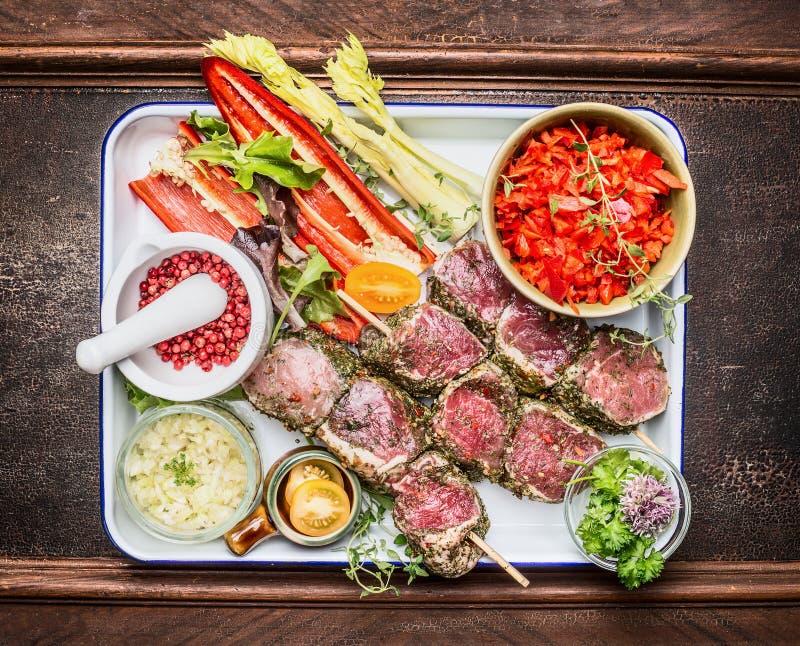 Rohe marinierte Fleischaufsteckspindeln mit Gewürzen und Gemüse für Grill oder Röstung stockfotografie