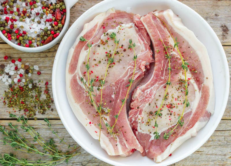 Rohe Schweinekoteletts Mit Dem Thymian, Salz Und Pfeffer Bereit Zu Den ...