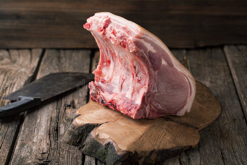Rohes Schweinekotelett und eine Axt lizenzfreies stockfoto Rohes Schweinekotelett und eine Axt lizenzfreies stockfoto