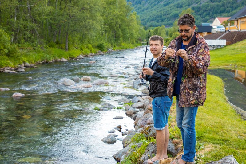 Roldal Norge - 26 06 2018: Fadern och sonen är fishermans flyger fiske i floden nära den Rodal staden, Norge arkivbilder Roldal Norge - 26 06 2018: Fadern och sonen är fishermans flyger fiske i floden nära den Rodal staden, Norge arkivbilder
