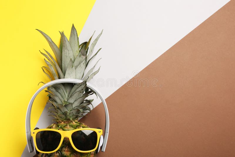 Rolig ananas med hörlurar och solglasögon på färgbakgrund, bästa sikt arkivfoton Rolig ananas med hörlurar och solglasögon på färgbakgrund, bästa sikt arkivfoton