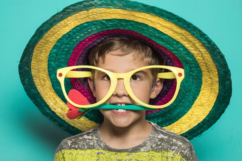 Rolig bild av en unge med stöttor Unge med en mexicansk hatt royaltyfri bild Rolig bild av en unge med stöttor Unge med en mexicansk hatt royaltyfri bild