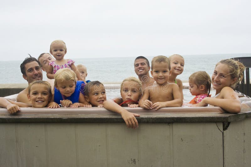 Cousins, nieces, nephews, aunts and uncles all having fun together as a family in the hot tub while at a family reunion. Cousins, nieces, nephews, aunts and uncles all having fun together as a family in the hot tub while at a family reunion