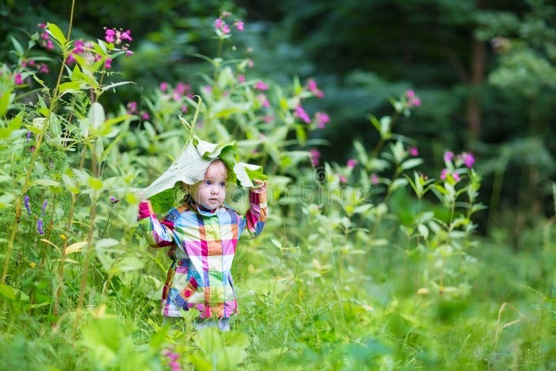 Roligt behandla som ett barn flickan som spelar titt en bu i en parkera under enorma sidor fotografering för bildbyråer Roligt behandla som ett barn flickan som spelar titt en bu i en parkera under enorma sidor fotografering för bildbyråer