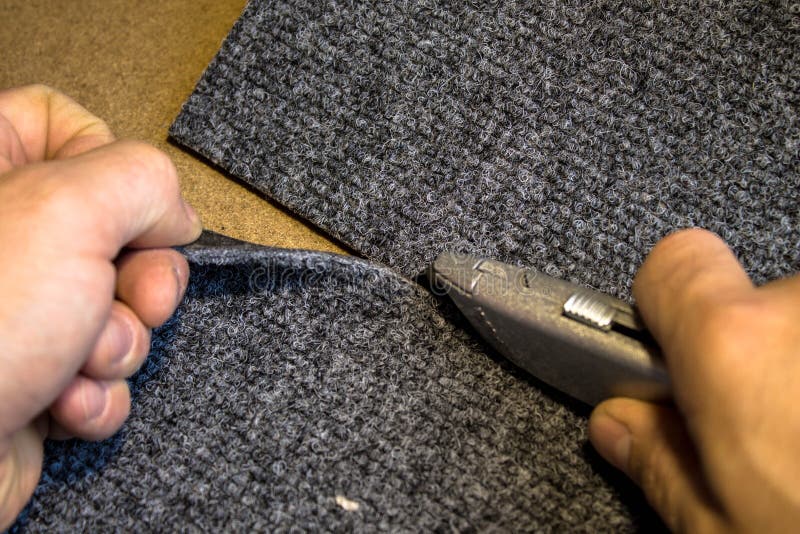 Grey roll of carpet and a knife for slicing stock images