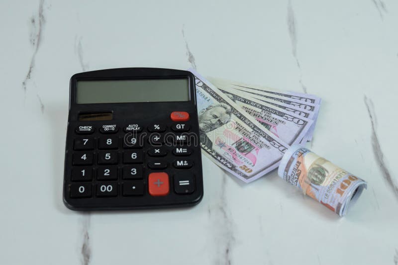 Roll of Dollar banknotes and calculator on the table royalty free stock photography