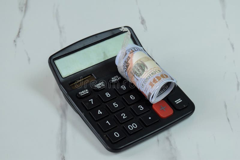 Roll of Dollar banknotes and calculator on the table stock images