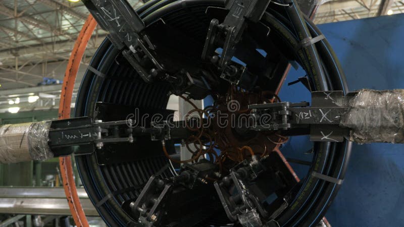 Roll threading coil pipe. Manufacture of plastic water pipes factory. Process of making plastic tubes on the machine stock photography