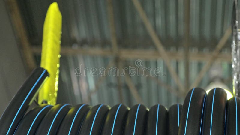 Roll threading coil pipe. Manufacture of plastic water pipes factory. Process of making plastic tubes on the machine stock images