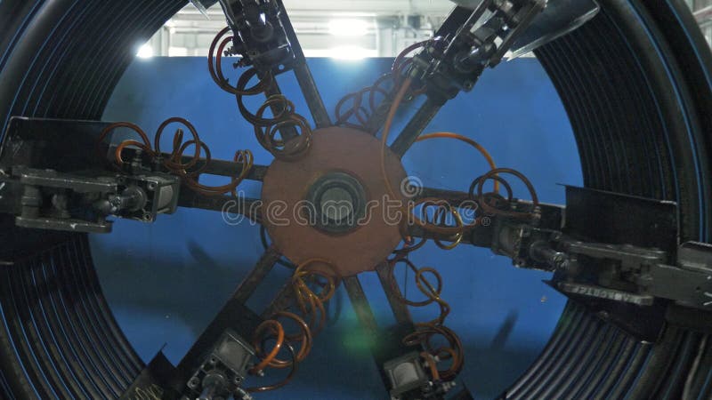 Roll threading coil pipe. Manufacture of plastic water pipes factory. Process of making plastic tubes on the machine stock photos
