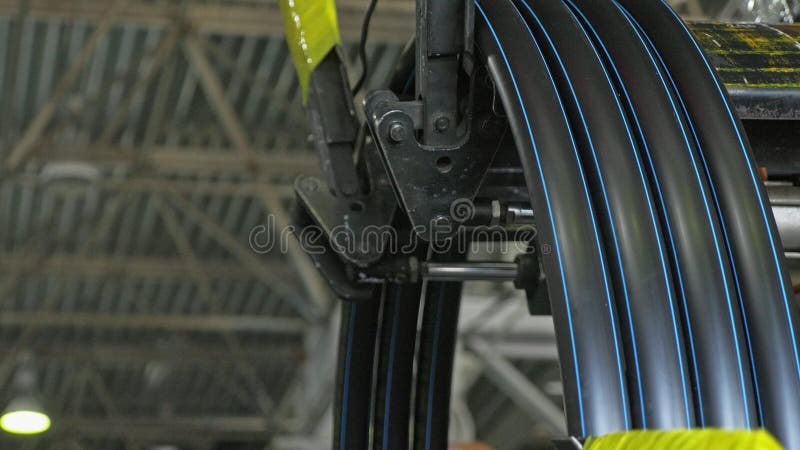 Roll threading coil pipe. Manufacture of plastic water pipes factory. Process of making plastic tubes on the machine royalty free stock photography