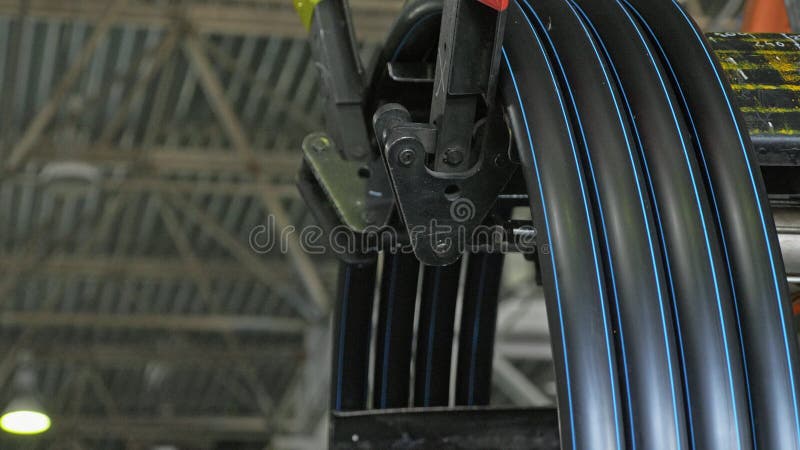 Roll threading coil pipe. Manufacture of plastic water pipes factory. Process of making plastic tubes on the machine stock photo