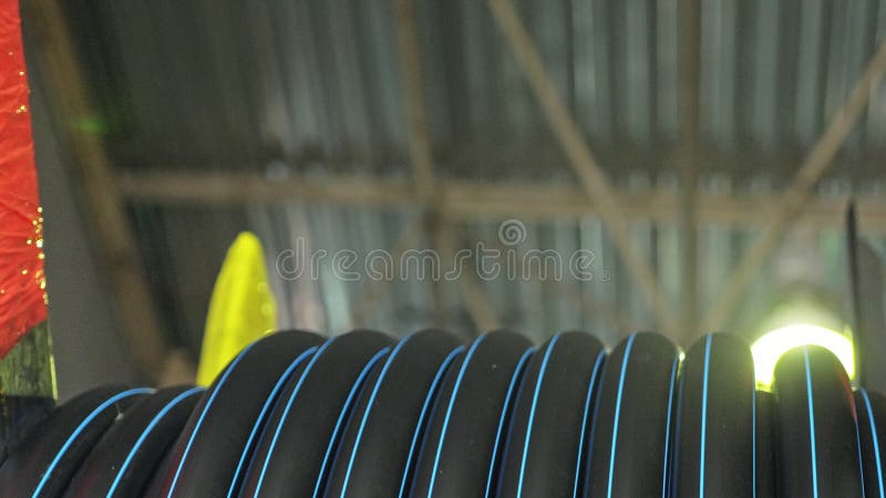 Roll threading coil pipe. Manufacture of plastic water pipes factory. Process of making plastic tubes on the machine stock image