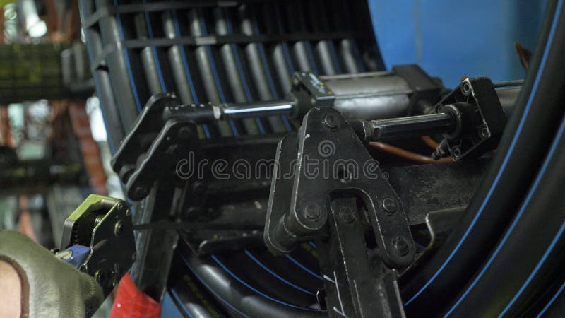 Roll threading coil pipe. Manufacture of plastic water pipes factory. Process of making plastic tubes on the machine royalty free stock photos