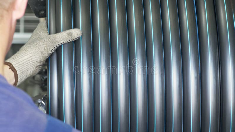Roll threading coil pipe. Manufacture of plastic water pipes factory. Process of making plastic tubes on the machine royalty free stock image