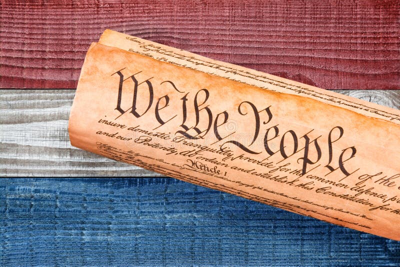A rolled copy of the USA Constitution on red, white and blue boards background. Patriotic background for 4th of July or Memorial