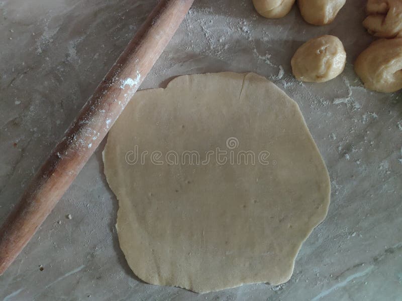 Rolled dough, rolling pin and fresh yeast dough for pizza or bread, cut into small pieces and rolled into the balls. Dough rolled into balls. Homemade dough. Small balls of dough on a marble table. Making of bakery products. Round baking. Raw fresh yeast dough stock images, royalty-free photos and pictures