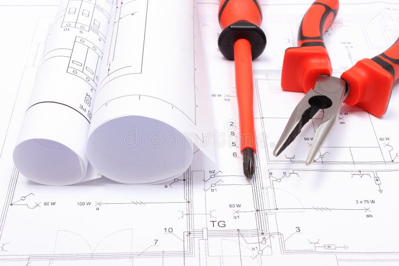 Rolled electrical diagrams and work tools on construction drawing of house royalty free stock photography