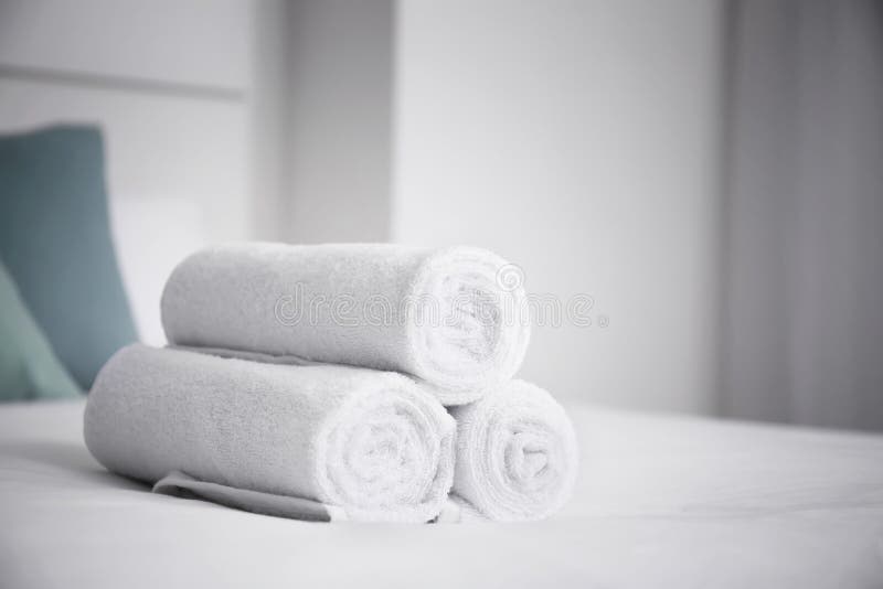 Rolled white towels on bed stock image. Image of soft 151317607