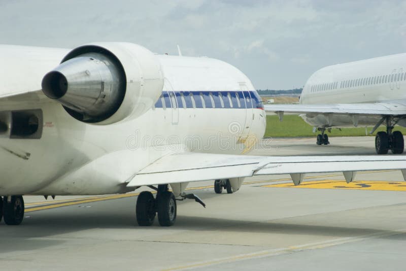 Two airplanes taxiing across a busy airport. Two airplanes taxiing across a busy airport