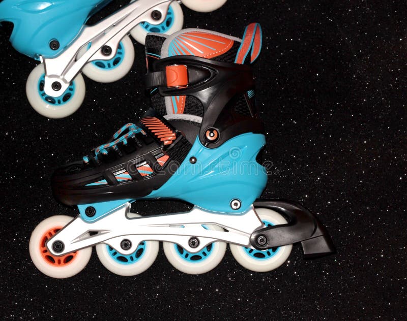 Roller Skates on a Black Background. Rollers are Black and Blue with